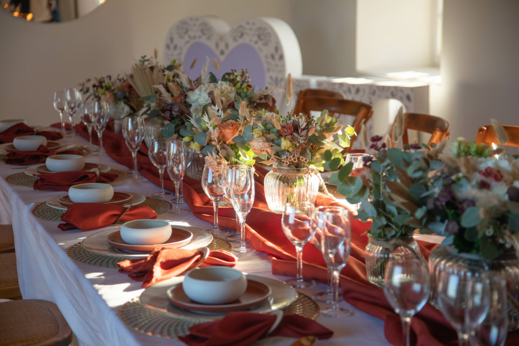 table de mariage dressée en blanc et chemin de table terracotta et fleurs sèchées