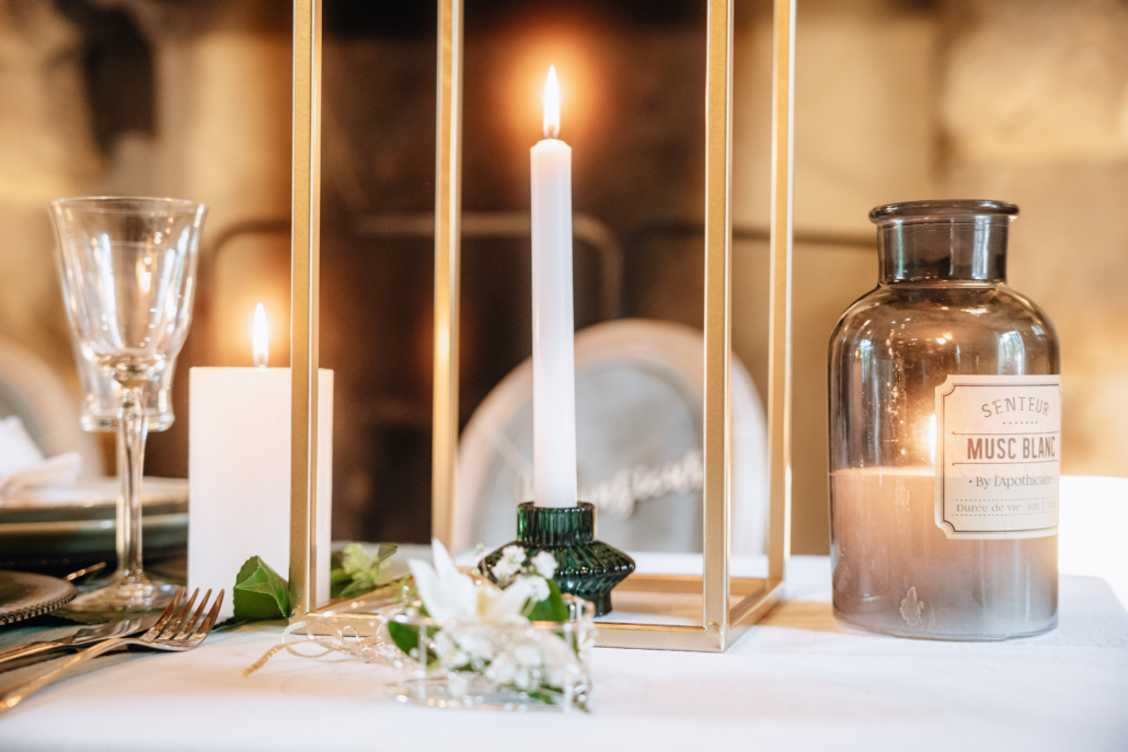 bougie blanche posée sur une table de mariage by glad events