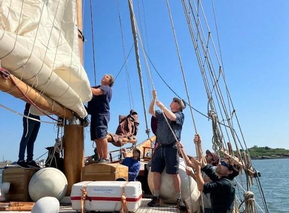 équipe à bord d'un voilier en train de hisser une voile - séminaire glad events en Bretagne-