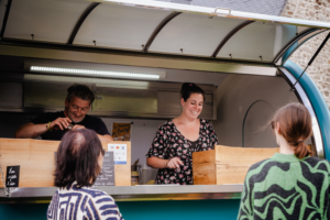 Propriétaire du food truck crêpes galette en cours de service le haut-vent ouvert