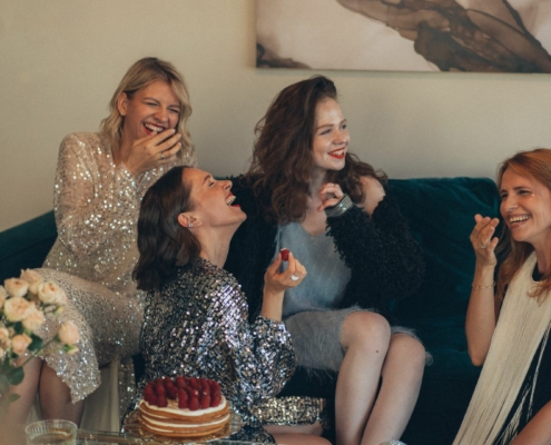 femmes assises sur un canapé en tenues de soirée en train de rire