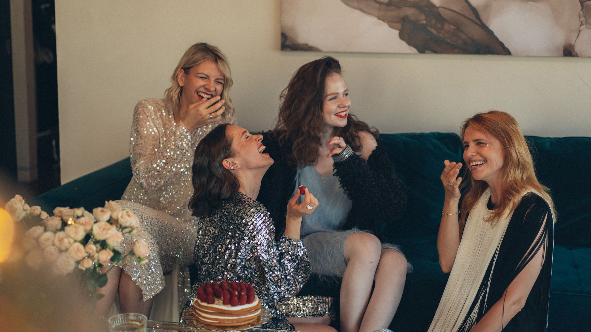 femmes assises sur un canapé en tenues de soirée en train de rire
