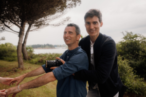 Photographe vidéaste en cours de prise de vue enlassant le marié, l'appareil sur son torse pour capter ce qu'il voit en face.