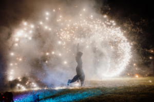 Danseurs de feu dans un halo de fumé et lumière blanche