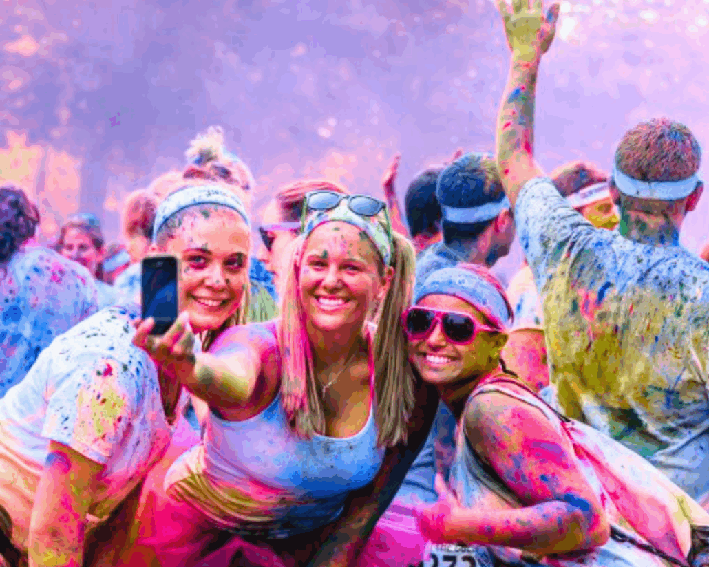 Femmes qui se prennent en photos en souriant après un color fight - les colors fights de Glad events, une activité énergique et pleine de rire pour vos EVG et EVJF