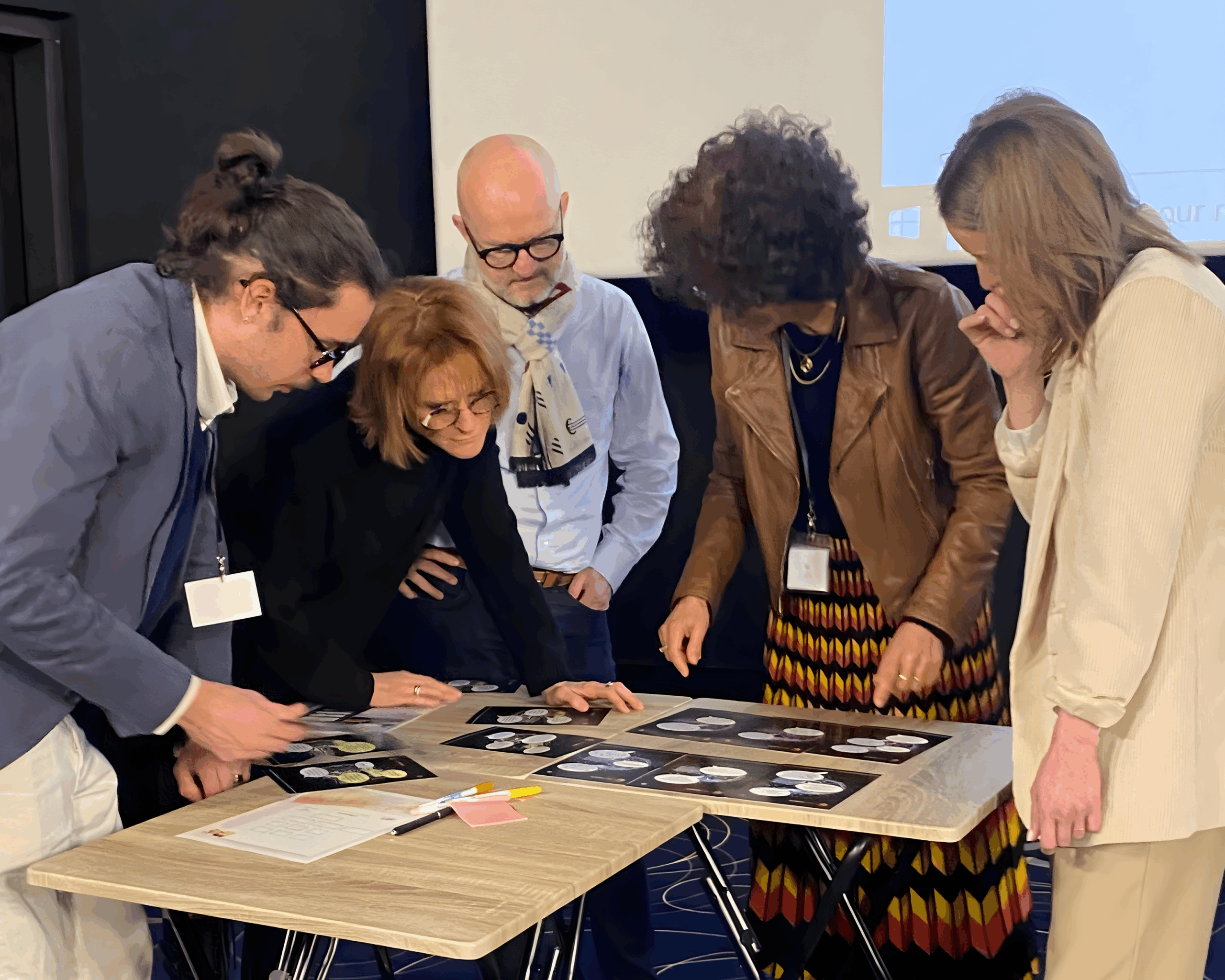 Team building RPS par Glad events en Bretagne team building sur les risques psychosociaux par Gled events - agence evenementeille en Bretagne - les participants sont regroupés autour d'une table en train de lire les cartes qui racontent l'histoire de ce qui se passe dan l'entreprise level up, une entreprise fictive où les participants retrouve des cas de burnout, harcèlement moral et sexuek et agression externe et interne. Un jeu pour sensibiliser les équipes terrain à ces situation