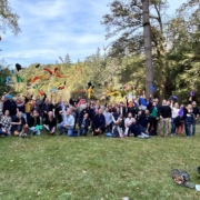Groupe rassemblé sous les arbres lors d'un team building Glad events en Bretagne. Certains lancent leur fanions de couleurs différentes qui symbolisaient l'équipe à laquelle ils appartenait durant le jeu. Tous sourient et sur heureux