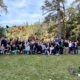Groupe rassemblé sous les arbres lors d'un team building Glad events en Bretagne. Certains lancent leur fanions de couleurs différentes qui symbolisaient l'équipe à laquelle ils appartenait durant le jeu. Tous sourient et sur heureux