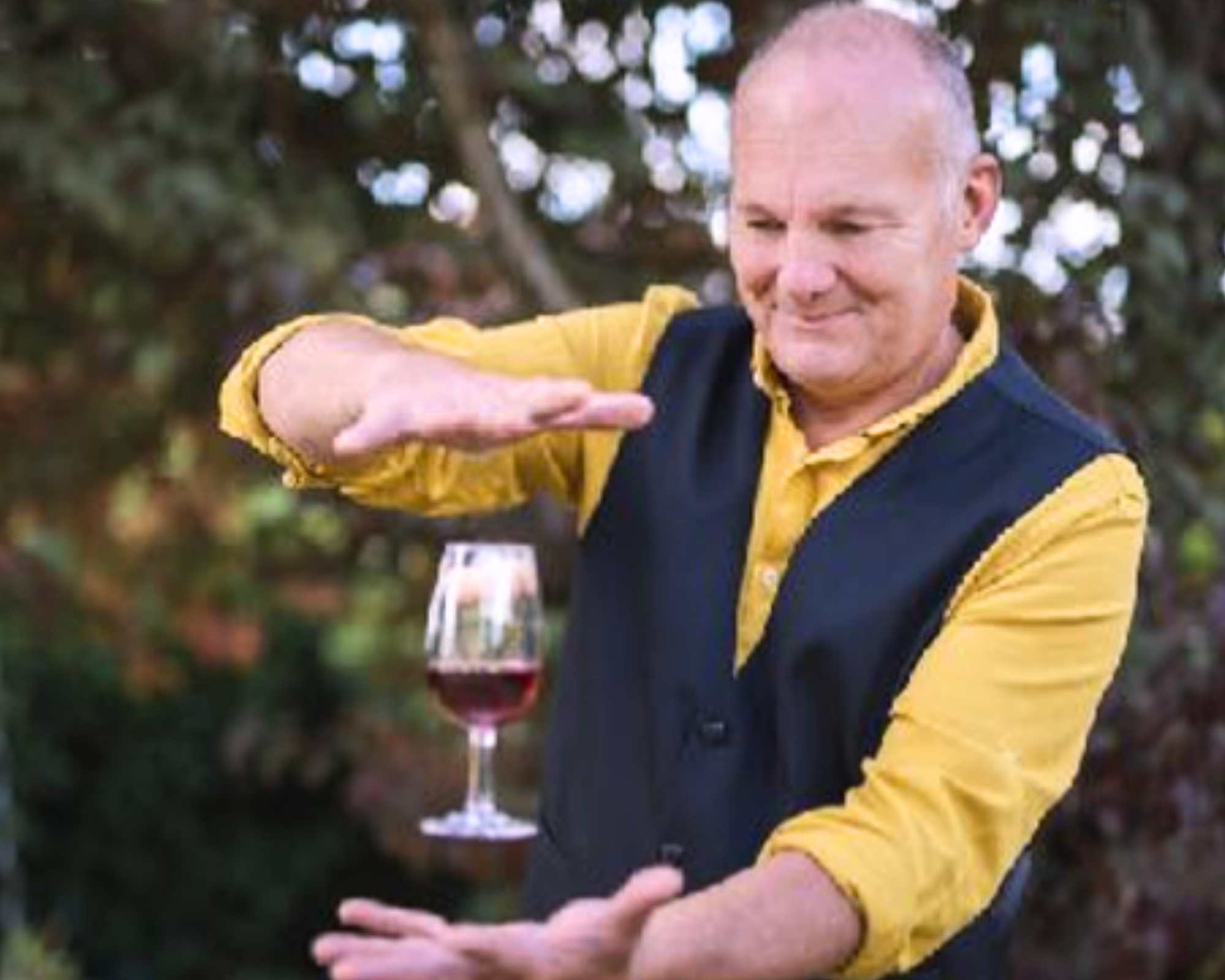 Visuels site internet team building Glad events pro (11) Magicien oenologue en train de faire tenir un verre de vin rouge en suspension entre ses deux mains placées au dessus et en dessous lors d'un team building Glad events