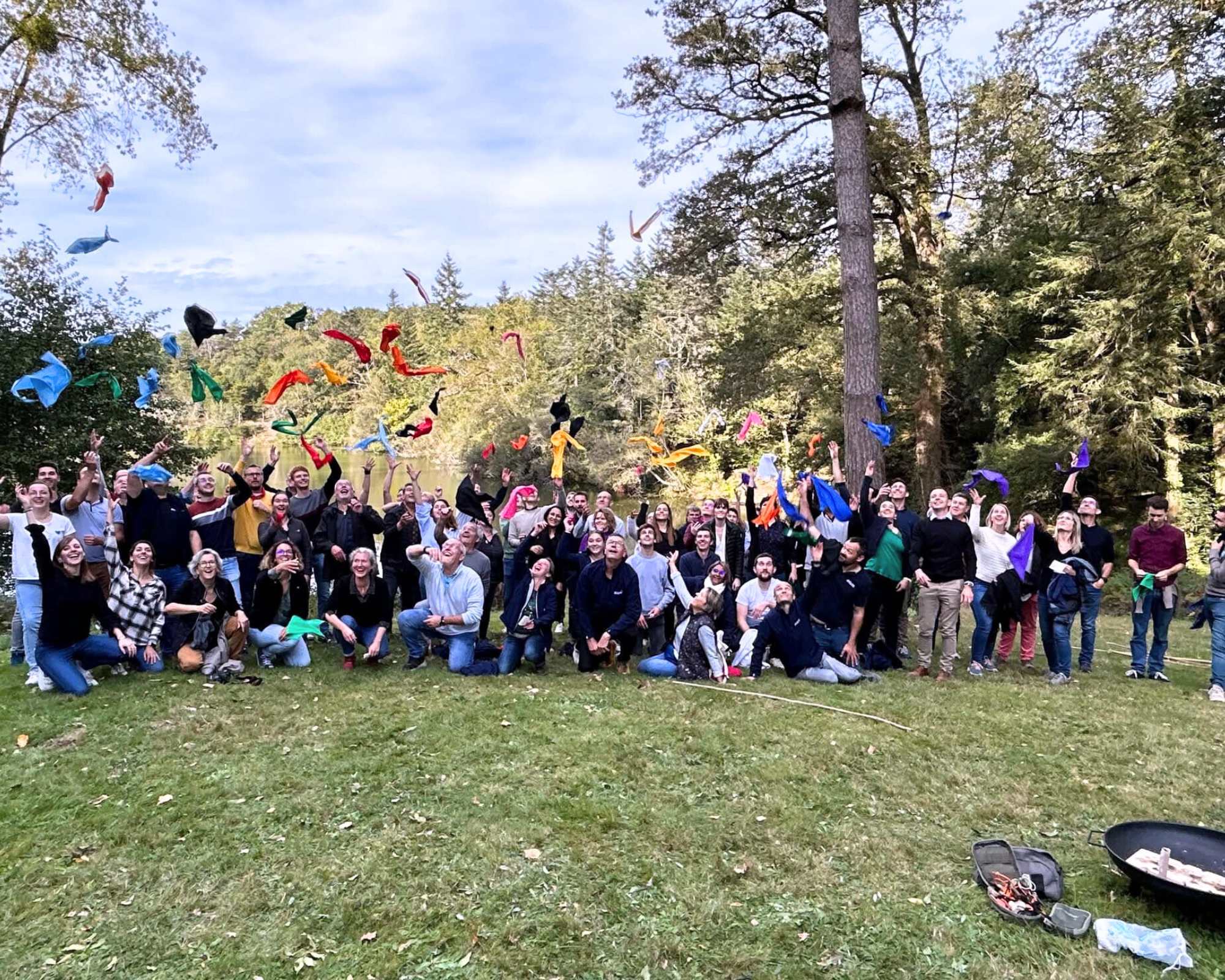 team building olympiade des défis 2 Glad events pro grands groupe de 80 personnes regroupés à l'extérieur dans une prairie avec des arbres pour la photo finale de leur team building olympiade par Glad events à Quimper