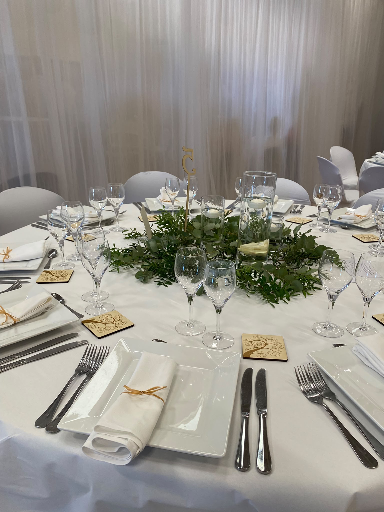salle de réception de mariage avec une décoration épurée blanche et champêtre légère à 25 euros par personne avec une option de mur séparateur de la salle de cocktail et de l'espace réception en tule blanc de 10m de longueur